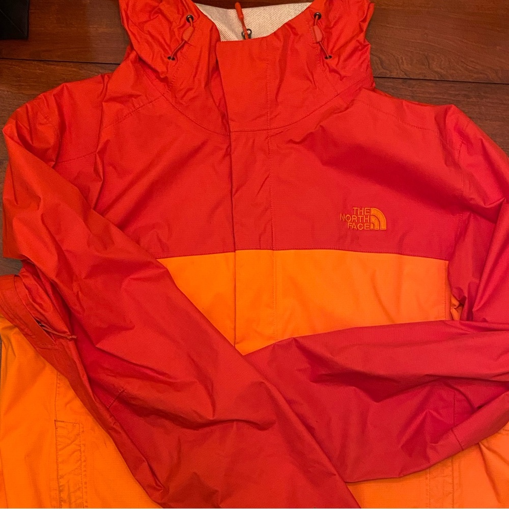 The north face Rain coat in bright orange used condition